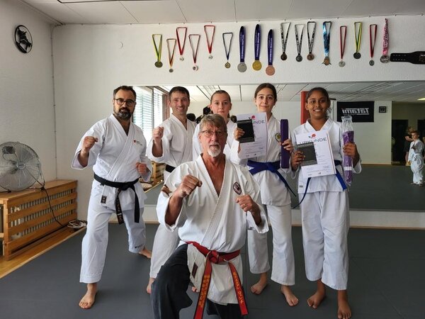 Junge Karate Ka und Trainer freuen sich über die bestande Prüfung
